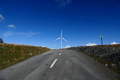 Distance shot of wind turbine with country road in foreground