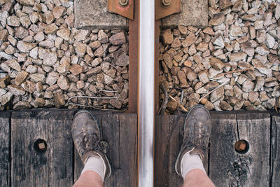 Low section of man standing on railroad track