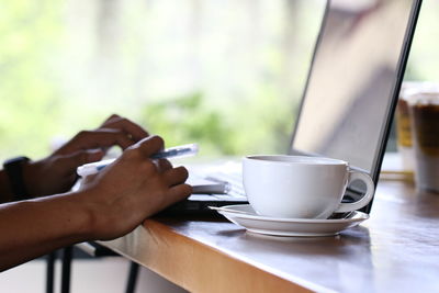 Midsection of coffee cup on table