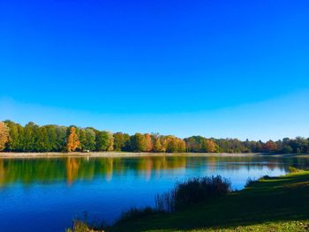 Scenic view of lake against clear blue sky