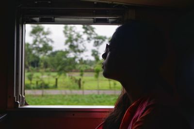 Portrait of woman looking through window