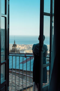 Close-up of person looking through window