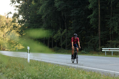 Strong bearded guy riding bike in protective helmet, mirrored glasses and sport clothing. 