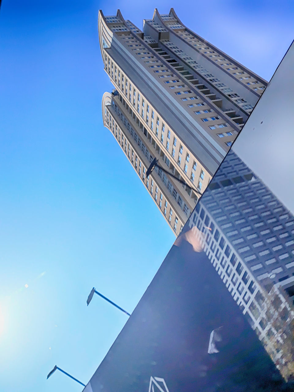 low angle view, building exterior, sky, built structure, architecture, building, nature, blue, clear sky, no people, tall - high, city, tower, day, office building exterior, sunlight, travel destinations, skyscraper, outdoors, office, modern, spire