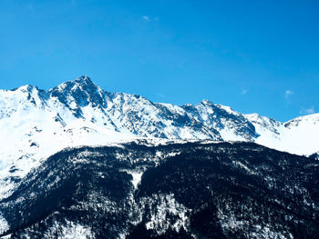 Scenic view of snowcapped mountains against clear blue sky