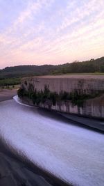 Scenic view of river against sky at sunset