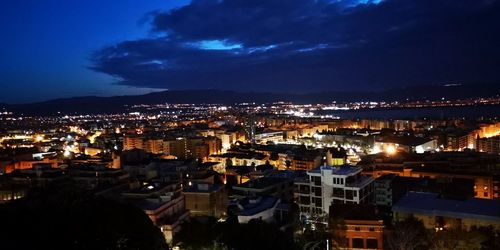 High angle view of illuminated cityscape against sky at dusk