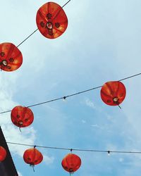 Low angle view of lanterns hanging against sky