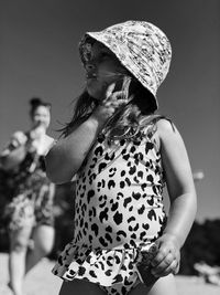 Low angle view of girl wearing hat standing outdoors