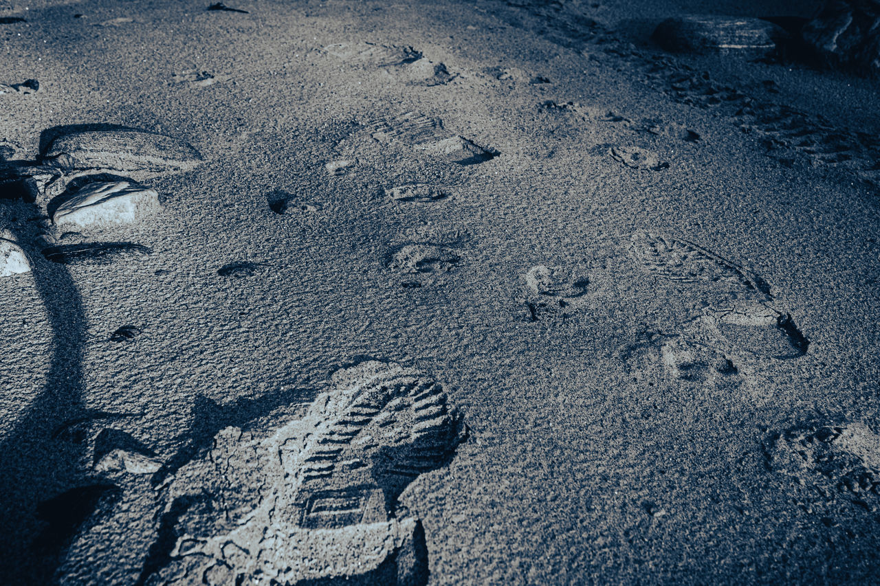 CLOSE-UP OF FOOTPRINTS ON SNOW COVERED LAND