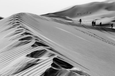 Distant view of people walking at desert