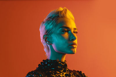 Low angle view of woman standing against yellow background