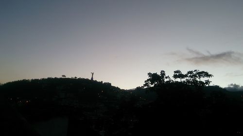 Low angle view of silhouette trees against clear sky