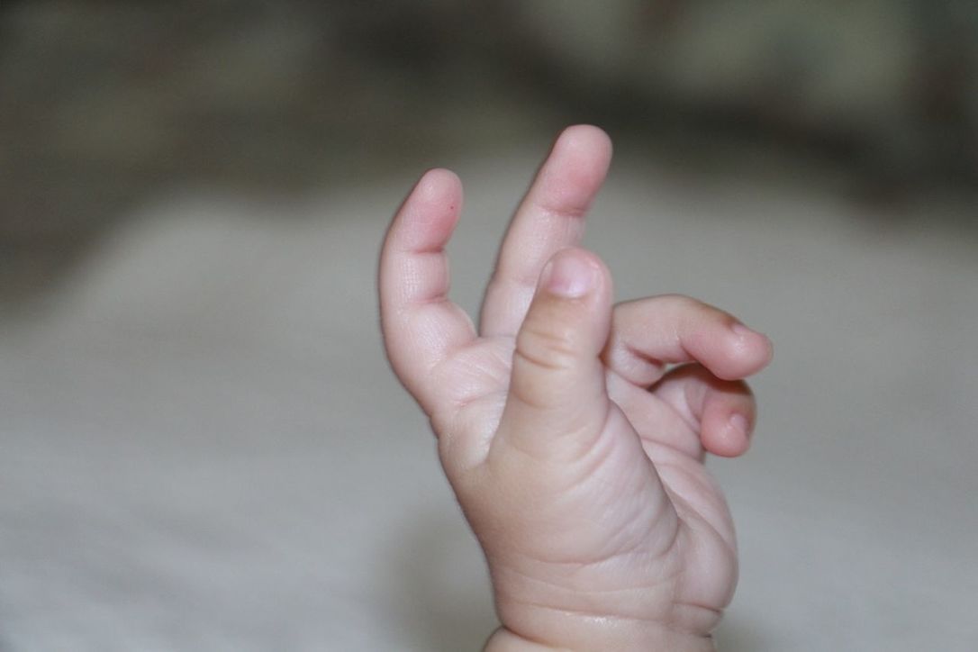 CLOSE-UP OF HAND HOLDING BABY FEET