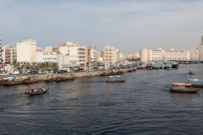 Boats in sea against buildings in city