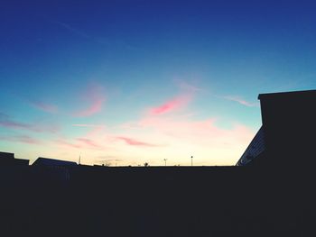 Silhouette city against sky during sunset