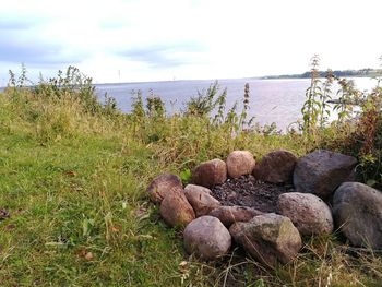 Stones by sea against sky