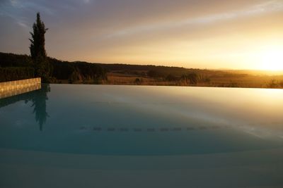 Scenic view of lake against sky at sunset