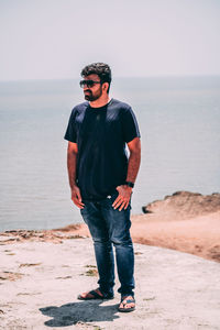 Full length of young man standing on beach