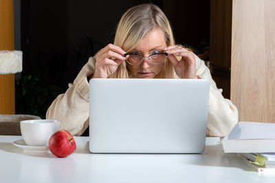 Portrait of woman using laptop on table