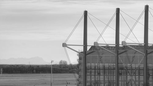 Suspension bridge over field against sky