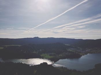 Scenic view of lake and mountains against cloudy sky