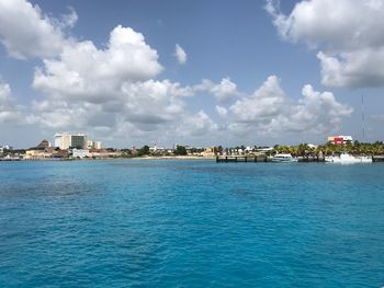 Scenic view of sea by buildings against sky