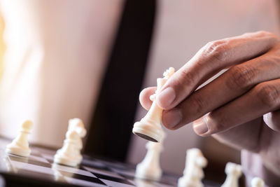 Cropped hand of person playing chess