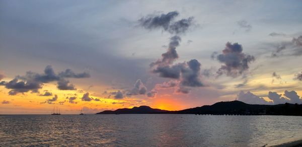 Panoramic view of sea against dramatic sky during sunset