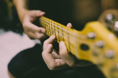 Midsection of man playing guitar