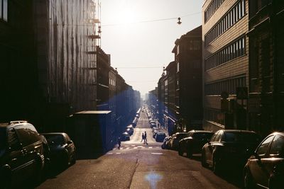 Cars on road amidst buildings in city