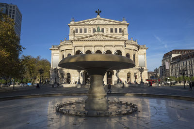 Statue in city against clear sky