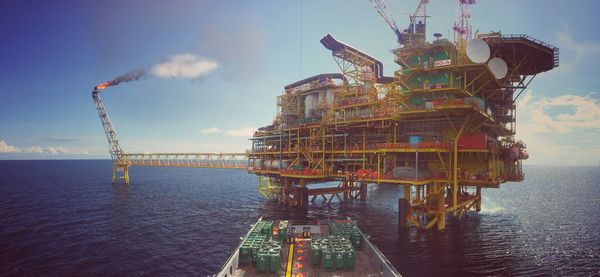 Offshore platform in sea against sky