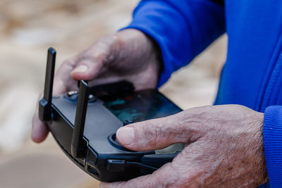 Close-up of old man operating drone using a remote control