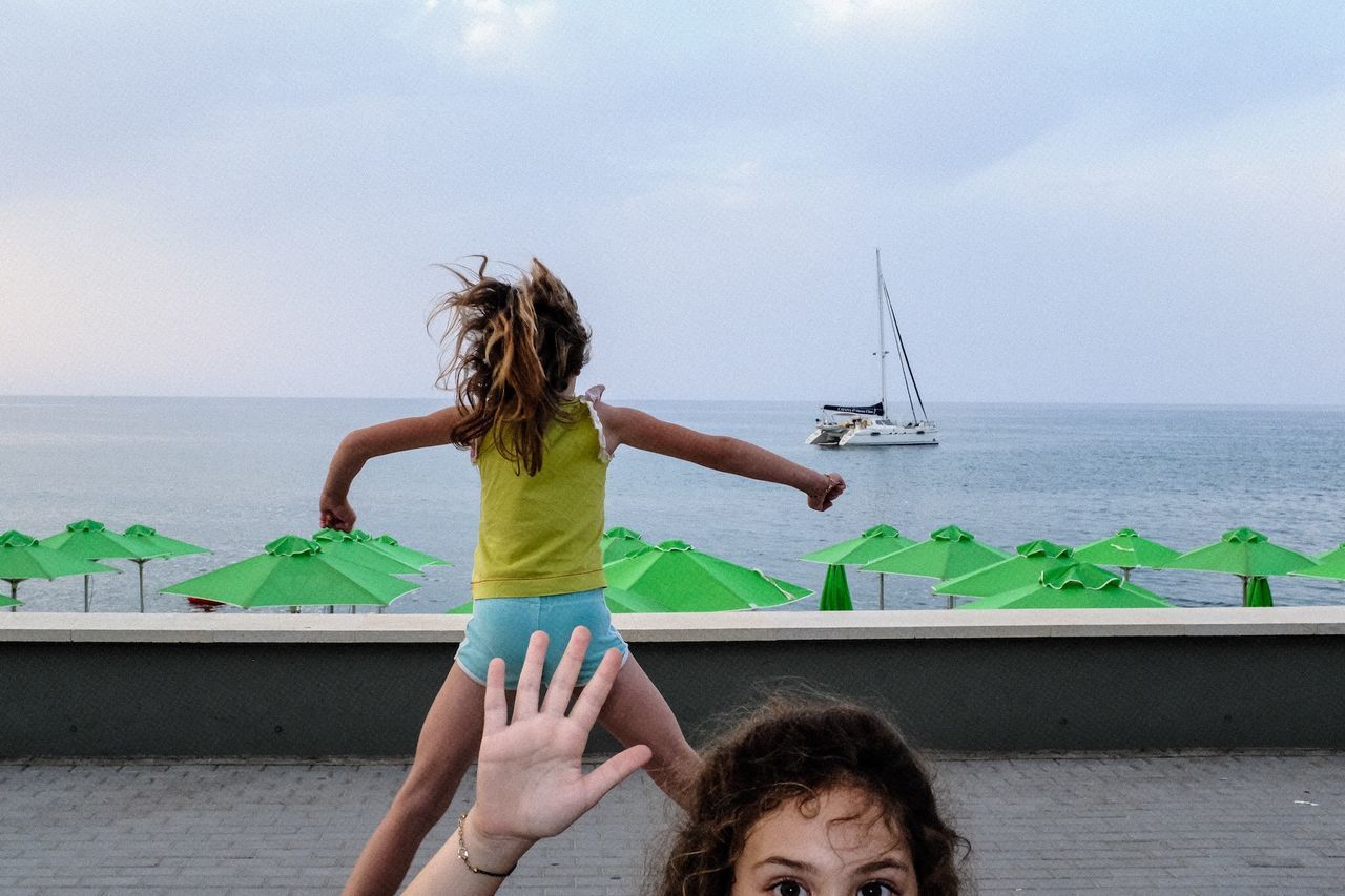 water, sea, sky, nautical vessel, leisure activity, real people, horizon, lifestyles, horizon over water, nature, women, scenics - nature, beach, transportation, people, land, hair, long hair, hairstyle, outdoors