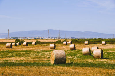 Hay bales on field against sky