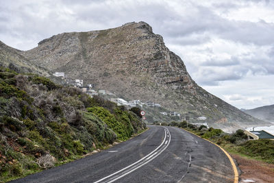 Road by mountain against sky