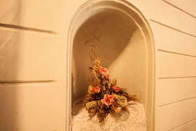 Flowers in niche of historic building wall