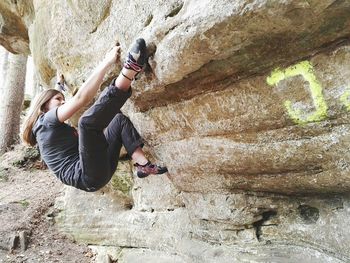 Full length of woman jumping on rock