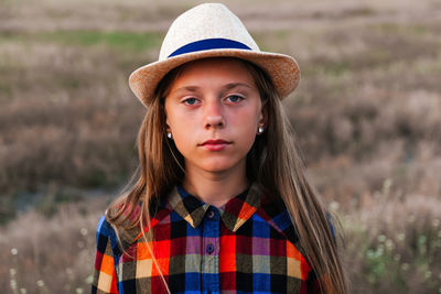 Portrait of young woman standing against plants