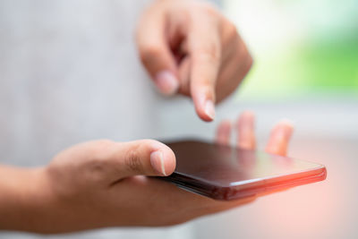 Cropped hand of man using mobile phone
