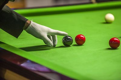 Cropped hand touching pool ball