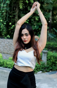 Portrait of beautiful young woman standing in park