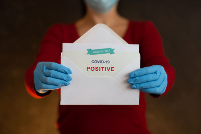 Midsection of woman holding umbrella standing by text
