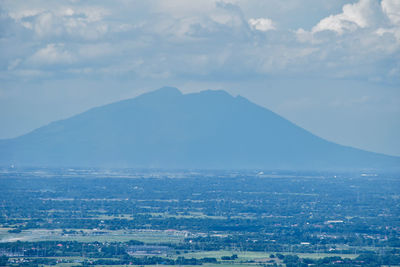 Aerial view of townscape and mountains against sky