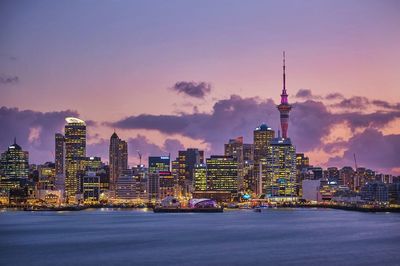 Illuminated cityscape against sky at sunset