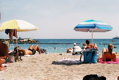People at beach against sky