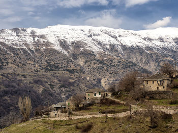 Scenic view of houses and mountains against sky