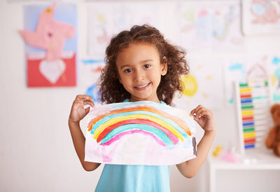 Portrait of smiling girl holding drawing