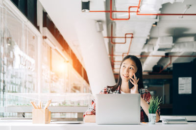 Woman using phone on table